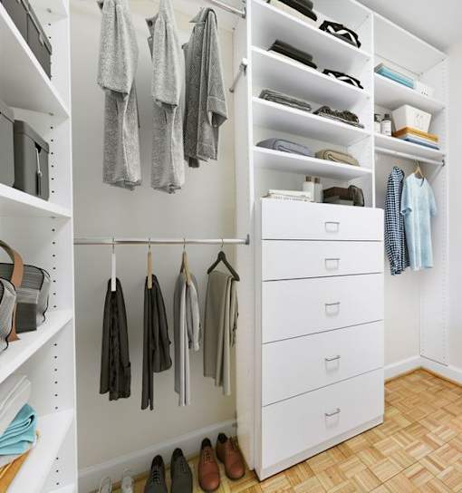 A white closet with clothes and shoes.