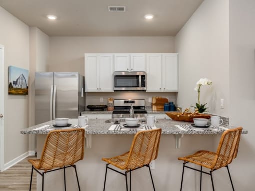 a kitchen with a counter top and three chairs