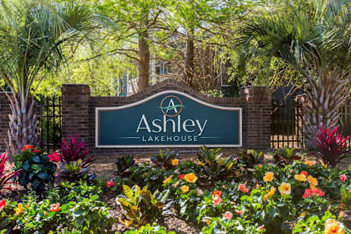 Ashley Lakehouse monument sign at apartment community entrance with palm trees and colorful landscaping in West Ashley, Charleston, SC.