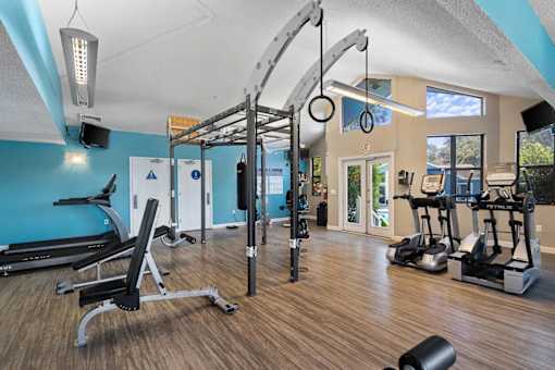 A gym with a variety of equipment including a treadmill, weights, and a pull up bar.