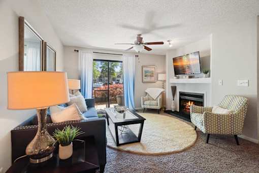 A living room with a fireplace, a chair, a sofa, a coffee table, and a television.