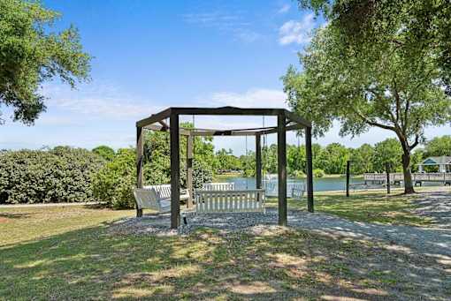 A gazebo in a park with a lake in the background.