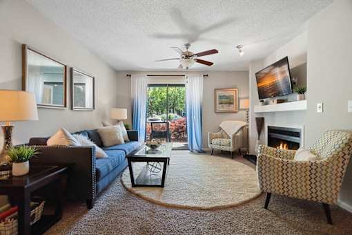 A living room with a couch, chair, and a fireplace.
