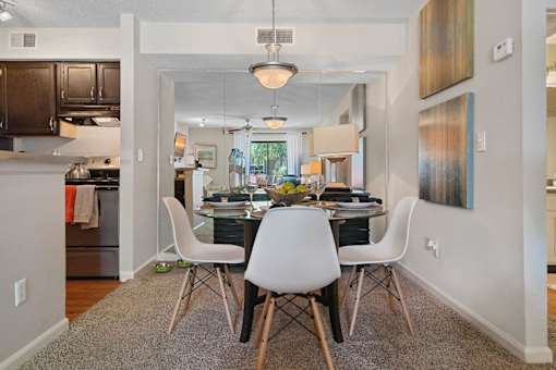 A dining room with a table and chairs.