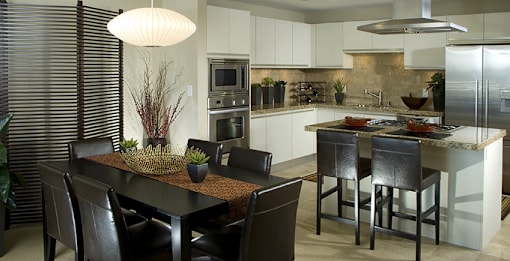A modern kitchen with a dining table and chairs.