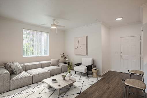 A living room with a grey sofa, a white armchair, a coffee table, and a rug.