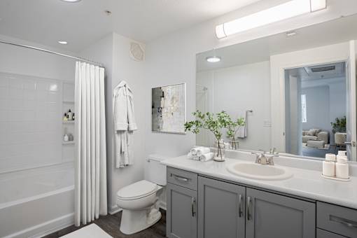 A white toilet sits in a bathroom next to a sink.