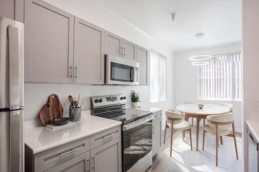 A modern kitchen with a refrigerator, oven, and microwave.