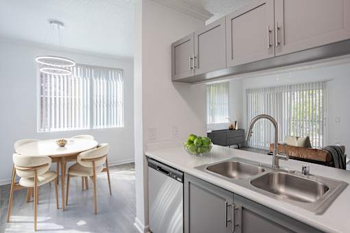 A kitchen with a dining table and chairs.