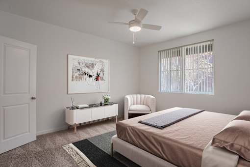 A bedroom with a bed, chair, and painting on the wall.
