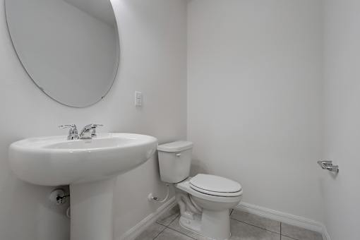 A white toilet sits next to a sink in a bathroom.