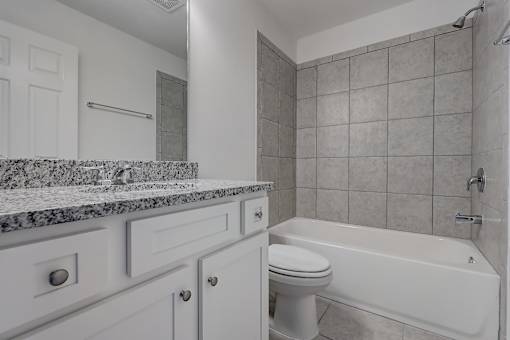 A white bathroom with a tub, toilet, and sink.
