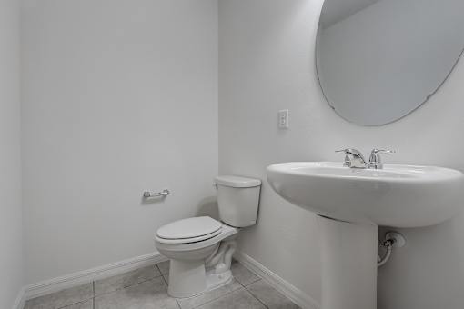 A white toilet and sink in a bathroom.