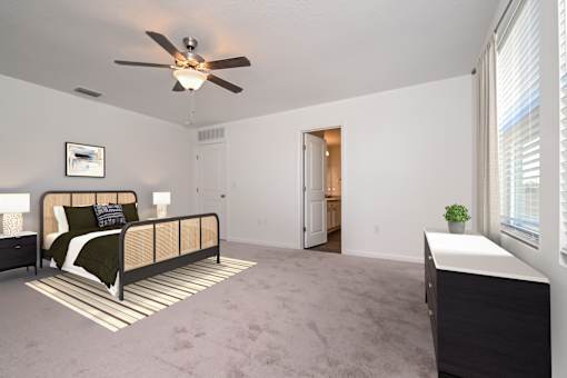 Homes in Ruskin, FL for rent - Ruskin Reserve - Luxury primary bedroom with connected bathroom and plush carpeting with ceiling fan