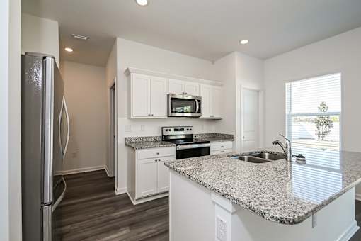Ruskin, FL Homes - Ruskin Reserve Luxury Kitchen with white cabinets wooden floors granite countertops
