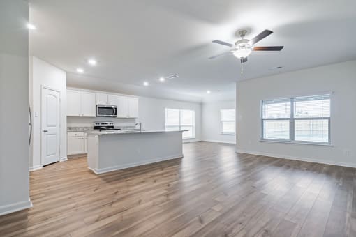Four Bedroom Homes for Rent in Denton, TX - Beall Way - Open-Concept Living Room with a Ceiling Fan and a View of the Kitchen and Dining Room.