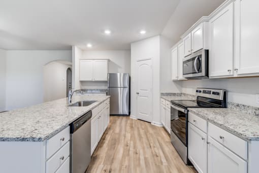 Three Bedroom Homes for Rent in Denton, TX - Beall Way - Kitchen with Granite Countertops, White Cabinets, and Stainless Steel Appliances.