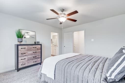 Four BR Apartments in North Denton, TX - Beall Way - Large Furnished Bedroom with Wall-to-wall Carpeting, Ceiling Fan, Large Closet, and Attached Bathroom.