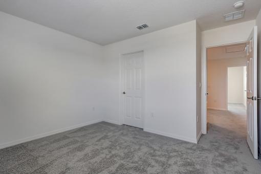 A room with a carpeted floor and a white door.