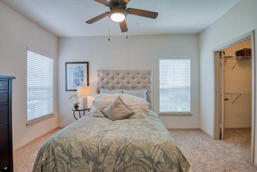 bedroom with carpet and ceiling fan and walk in closet and window with blinds