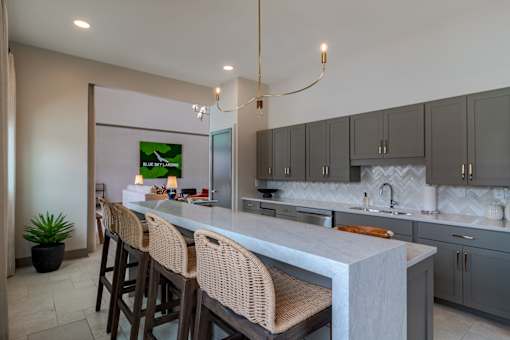 Modern clubhouse kitchen and entertaining space at Blue Sky Landing apartments in College Park, GA featuring island seating near Camp Creek Marketplace, East Point and South Fulton.