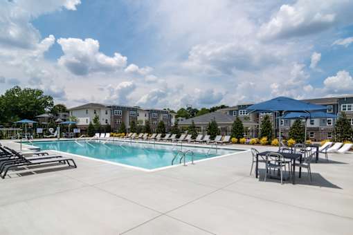 Spacious pool deck with lounge seating at Blue Sky Landing pet-friendly apartments in College Park, GA near Camp Creek Marketplace, East Point and South Fulton.