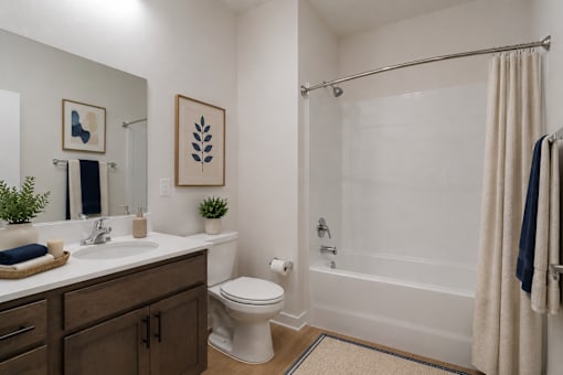 Modern bathroom at Blue Sky Landing featuring a spacious vanity, full-size bathtub and shower, contemporary fixtures, and stylish finishes in a brand-new apartment home in College Park, Georgia.