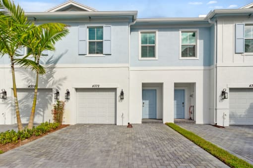 Boatman Hammock Townhomes in Lake Worth, FL photo of  a white house with two garage doors and a driveway