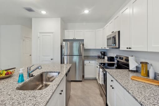 Boatman Hammock Townhomes in Lake Worth, FL photo of a large kitchen with granite counter tops and stainless steel appliances