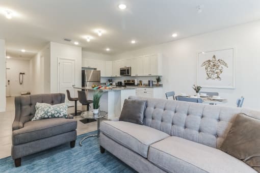 Boatman Hammock Townhomes in Lake Worth, FL photo of a living room with a couch and a chair and a kitchen