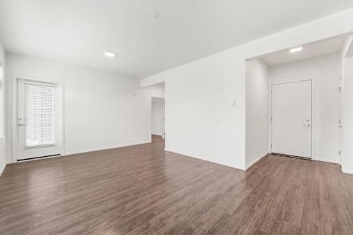 A room with wooden flooring and white walls.