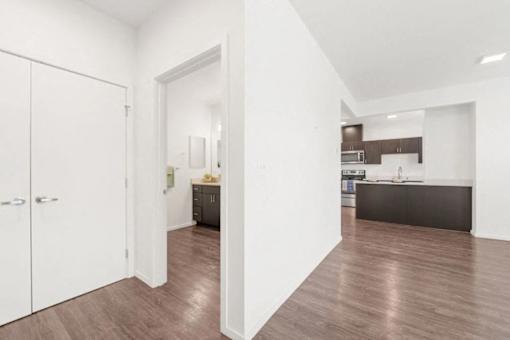 A kitchen with white cabinets and a wooden floor.