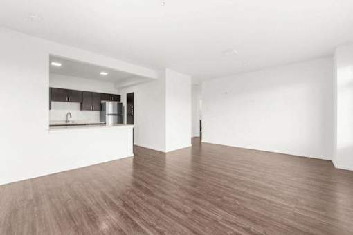 A room with wooden flooring and white walls.
