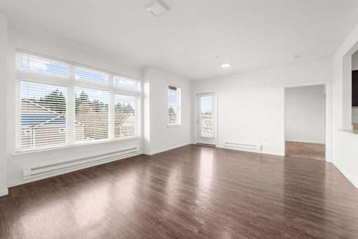A room with wooden flooring and white walls.