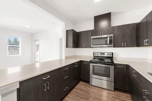 A modern kitchen with a stove and microwave built into the cabinetry.