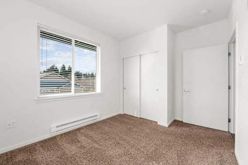 A room with a window and carpeted floor.