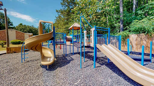Community playground at Broad on the Green in Augusta, Georgia featuring slides and swings for outdoor recreation.