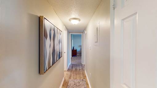 Hallway leading to bedroom at Broad on the Green in Augusta, GA, featuring Wood-Vinyl Plank Flooring in a pet-friendly apartment community.