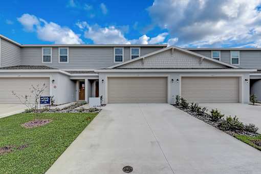 A residential house with a grey roof and two garages.