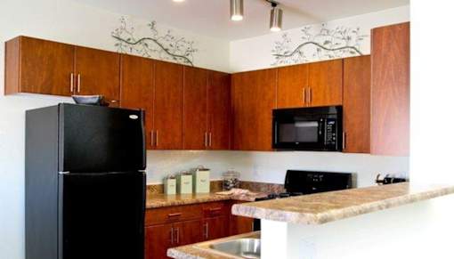 A kitchen with a black fridge and microwave.