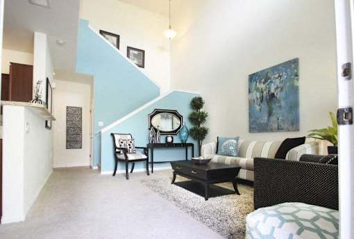 A living room with a couch, chair, and a painting on the wall.