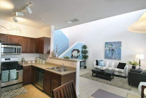 A modern kitchen with a dining area and a living room.