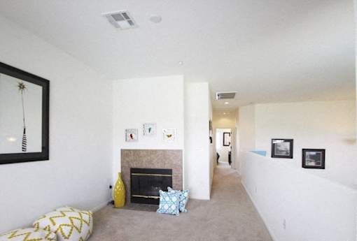 A living room with a fireplace and pictures on the wall.