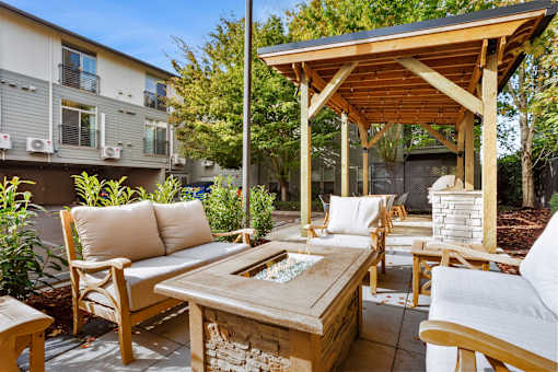 A wooden patio with a couch, chairs, and a table.