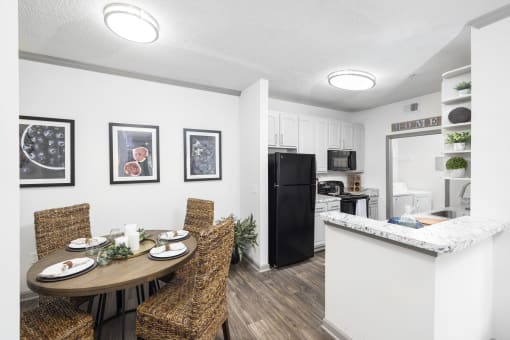 Apartments in Savannah, GA for Rent – The Palms at Chatham- a dining area with a table and chairs and a kitchen in the background
