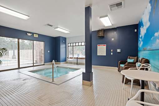 A room with a pool table and a hot tub.