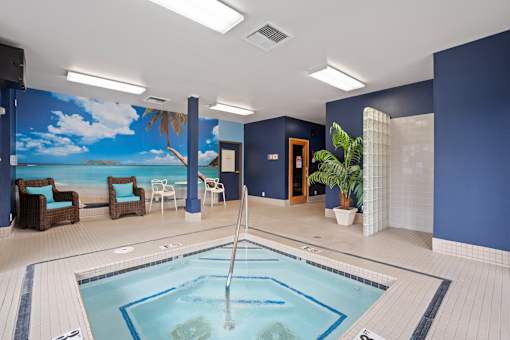 A large indoor swimming pool with a mural of a beach scene on the wall.
