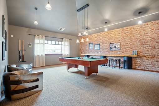 A room with a pool table and a couch.