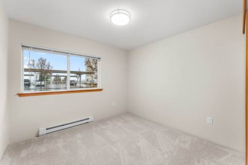 A room with a window and a radiator on the floor.