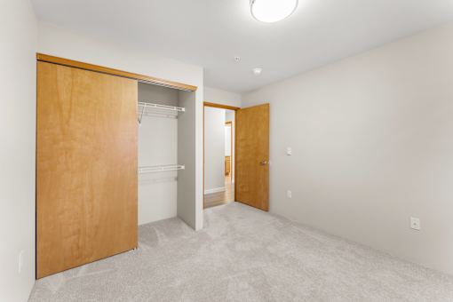 A room with a white wall and a brown door.
